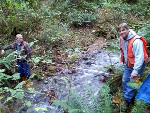 Demonstrating how to measure stream width to understand forest buffers.